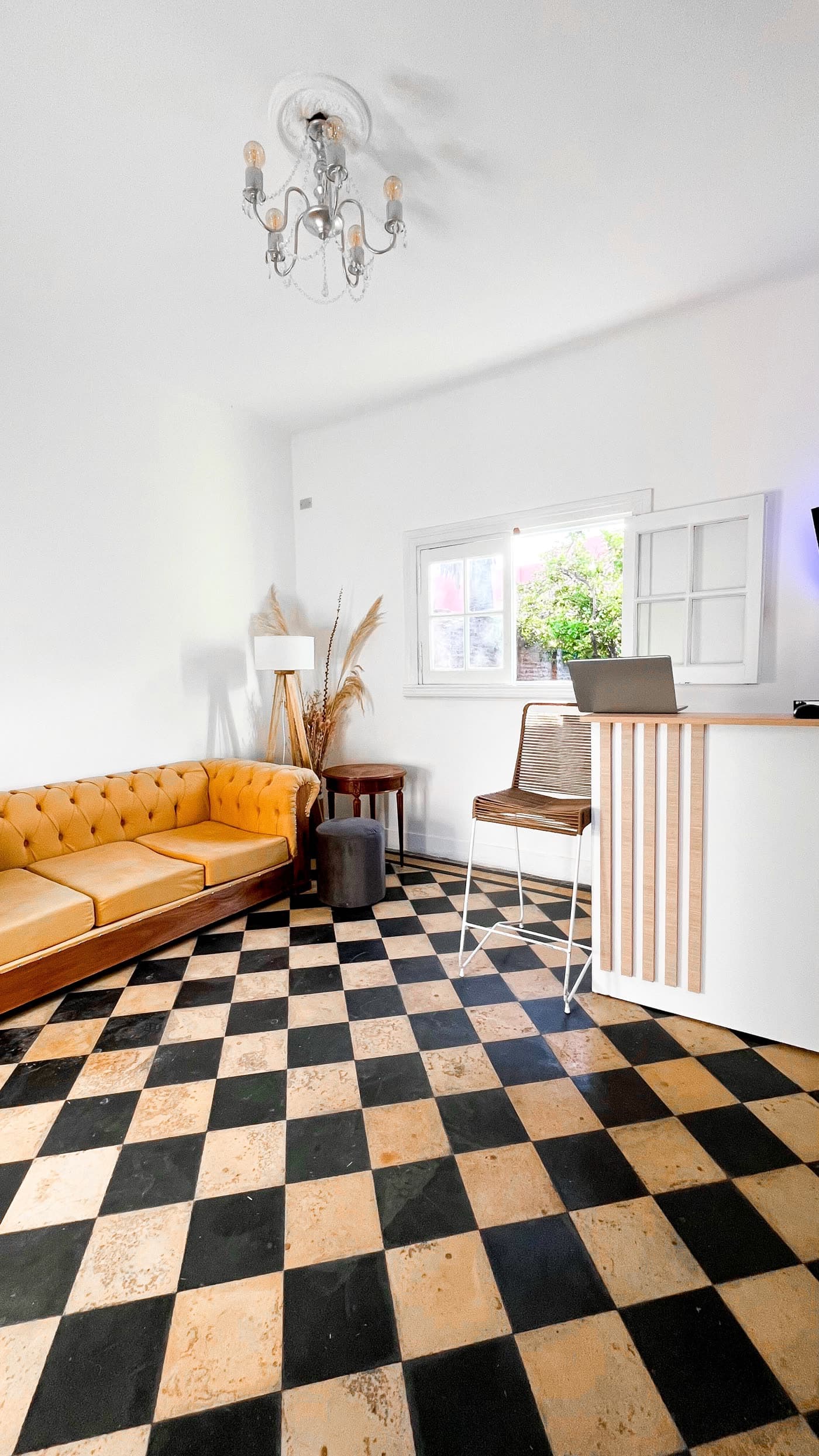 Salón de espera con piso damero y sillón mostaza